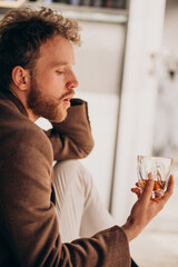 Handsome bearded man drinking whiskey