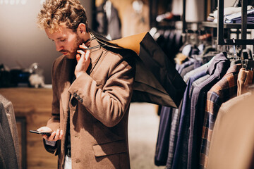 Young man at menswear shop talking on the phone