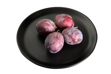 fresh plums in a black plate