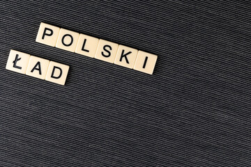 The sentence "Polski Ład" translated as  "Polish Order" on grey background. New taxation rules in Poland. Photo taken under artificial, soft light