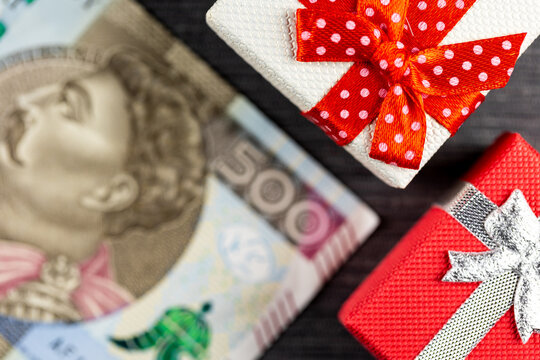 Polish 500PLN  banknote with presents arranged on a gray background. Small boxes with bows. Photo taken under artificial, soft light