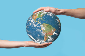 3D Earth planet globe in man, woman hand, hands on blue background. Environmental protection concept. Elements of this image furnished by NASA