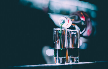 bartender hand making collection of colorful shots. two cocktails at the bar counter