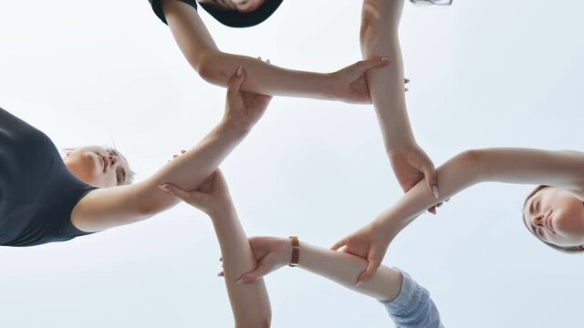 Friends join their wrists and make a circle. Strong friendship concept.