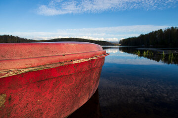A red old wooden boat anchored near the shore, in a secluded harbor.
Landscape photography of a...