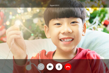 Web cam video call shot mock up. An adorable asian little boy in red sit in front of a bright and...