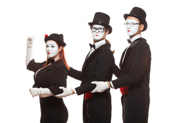 Portrait of three mime artists performing, isolated on white background. Mimes stand and hold on to each other. Symbol of leadership, co-working, team