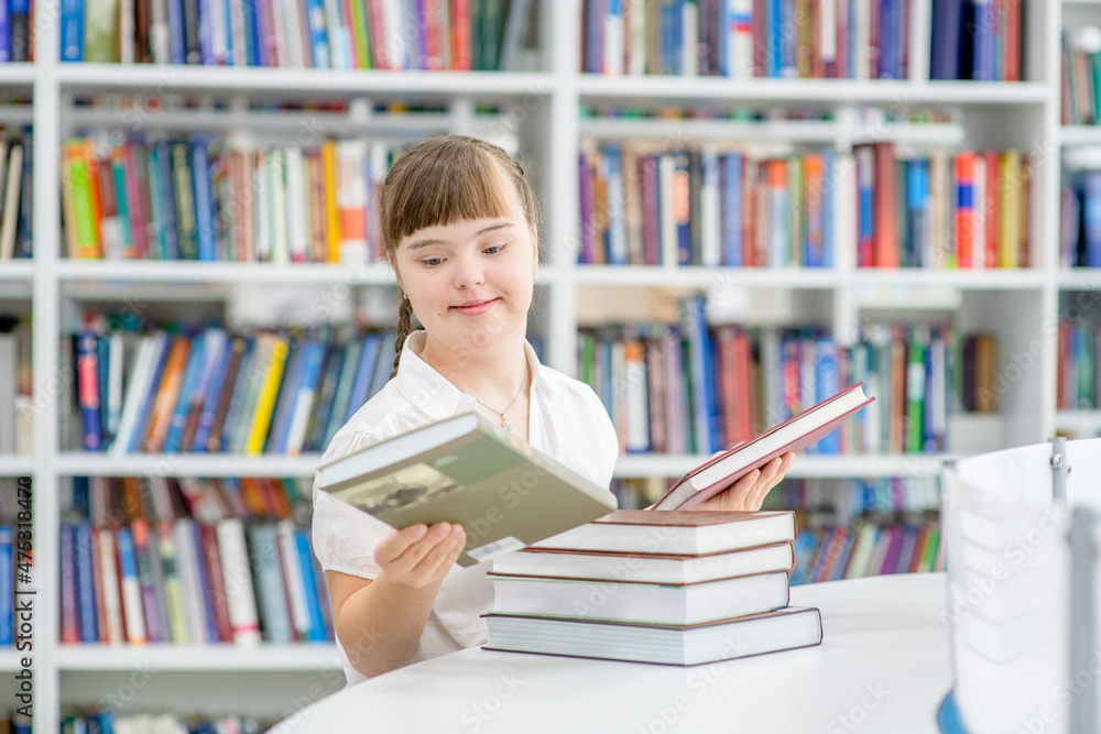 Wall mural smiling young girl with downs syndrom holds books at library