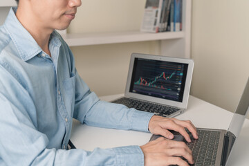 Trader, investor, business man is using computer laptop to trading, investment on stock market, Cryptocurrency as Bitcoin with technical price graph, Cryptocurrency or stock market trading chart.