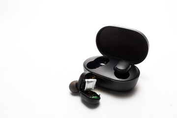 disassembled non-working wireless earphone and an open case