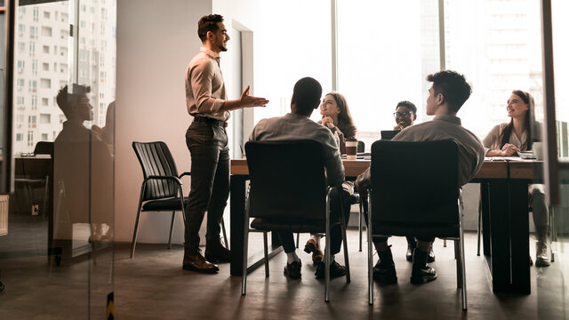 Colleagues having meeting in board room, businessman giving speech