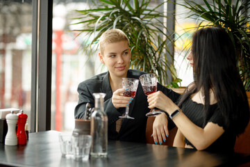 Lesbian couple on a date in a restaurant drinking wine