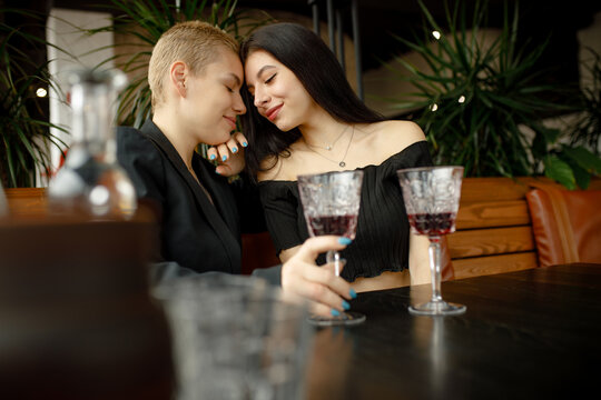 Lesbian Couple On A Date In A Restaurant Drinking Wine