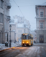Yellow tram on Market central square in winter Lviv city, Ukraine, Europe. Morning cityscape