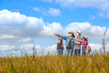 Children and mother learning and playing on grassland on blue sky background