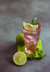A fresh pink cocktail or mocktail drink with lime, pink grapefruit juice and mint, green background. Paloma.