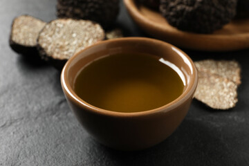 Obraz na płótnie Canvas Bowl of truffle oil on grey table, closeup