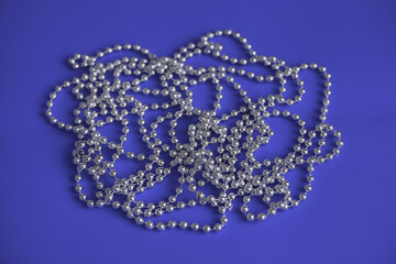 Shiny silver christmas tree beads on purple very peri  background