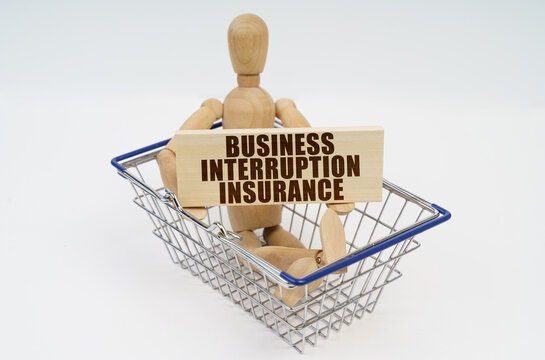 A wooden man sits in a shopping basket, holding a sign in his hands - Business Interruption Insurance