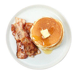Delicious pancakes with maple syrup, butter and fried bacon on white background, top view