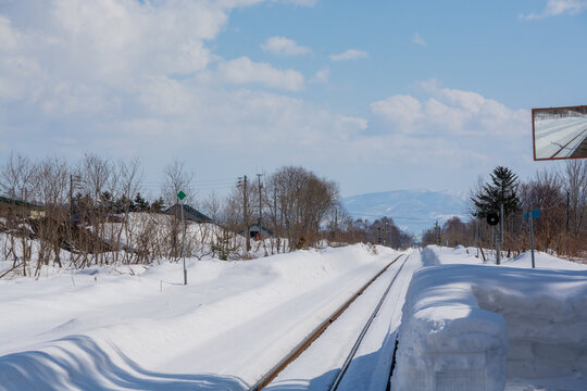 冬の田舎の無人駅と線路
