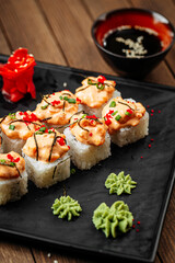 Fototapeta na wymiar Cheese ebi sushi rolls with wasabi and soy sauce on wooden background