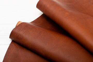 Brown folded natural cow leather on the wooden table	
