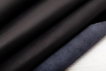 Dark brown folded natural cow leather on the wooden table