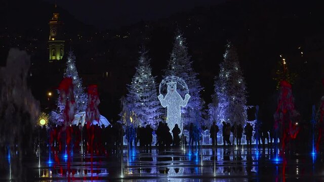 People attend Christmas decorations and coloured water fountains in Nice, France