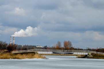 pipes of the cement plant against the background of the landscape and sky.