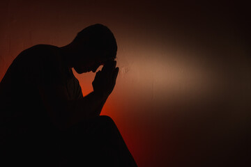 Silhouette of a man on a red background.
Silhouette of a guy in the dark.