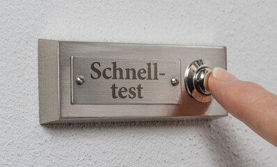 Person drückt Türklingel mit der Beschriftung Schnelltest