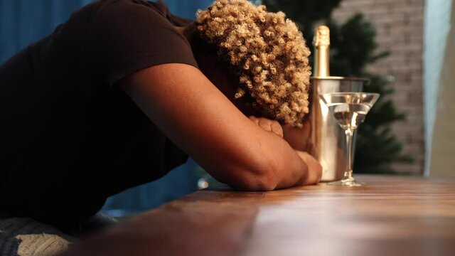 Young African-American man got very drunk and fell asleep sitting at the bar. Black man drank too much alcohol