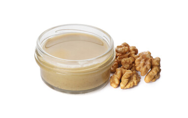 Jar with delicious walnut butter and nuts on white background