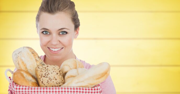 Composite image of caucasian woman holding a basket of bread against yellow wooden background