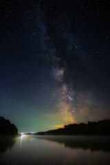 Fototapeta na wymiar Bright stars of the Milky Way in the night sky over the river. Wonderful place for landscape.