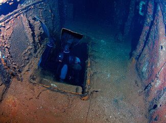 Scuba diver entering stairwell in sunken ship.