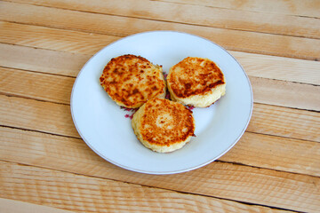 Homemade cheesecakes on a plate on the wooden background