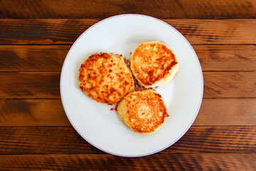 Homemade cheesecakes on a plate on the dark wooden background