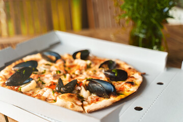 Crispy seafood pizza with mussels, squid and shrimps.
