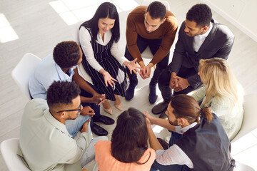 Top view of diverse employees or workers sit in circle talk engaged in teambuilding activity in...