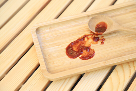 Dirty spicy sauce stain on wooden tray from using in serving. photo  for cleaning  concept of houeswork and clean tool product