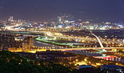 Fototapeta na wymiar Aerial panorama of Taipei Downtown at night with Dazhi Bridge over Keelung River, parks and highways along the riverside and skyscrapers in Nangang area at dusk ~ A romantic night scape of Taipei City