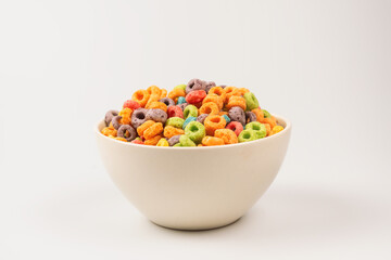Colorful rings cereal spill out into a bowl. Breakfast. Isolated.