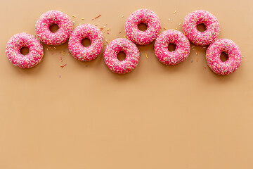 Set of pink glazed donutes with sprinkles, top view