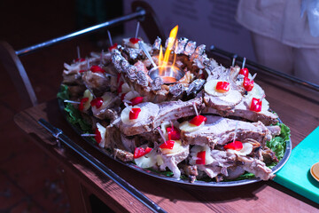 A waiter takes out a square of lamb at a wedding banquet.
