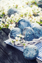 Obraz premium Easter marble eggs in a white bucket on the blue cloth