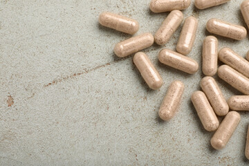 Gelatin capsules on light grey table, flat lay. Space for text