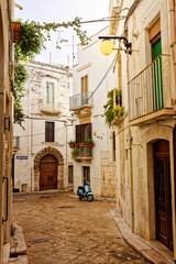 Obraz premium Blauer Motorroller in einer Gasse in Putignano, Italien, Apulien