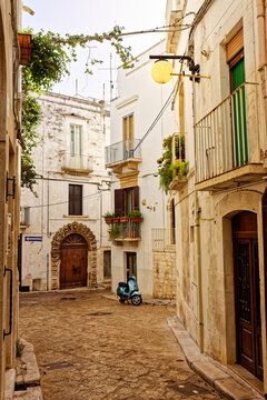 Blauer Motorroller in einer Gasse in Putignano, Italien, Apulien